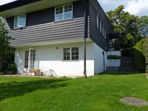 Blick auf die Aussenseite vom Wohnzimmer, links die Verandatuer